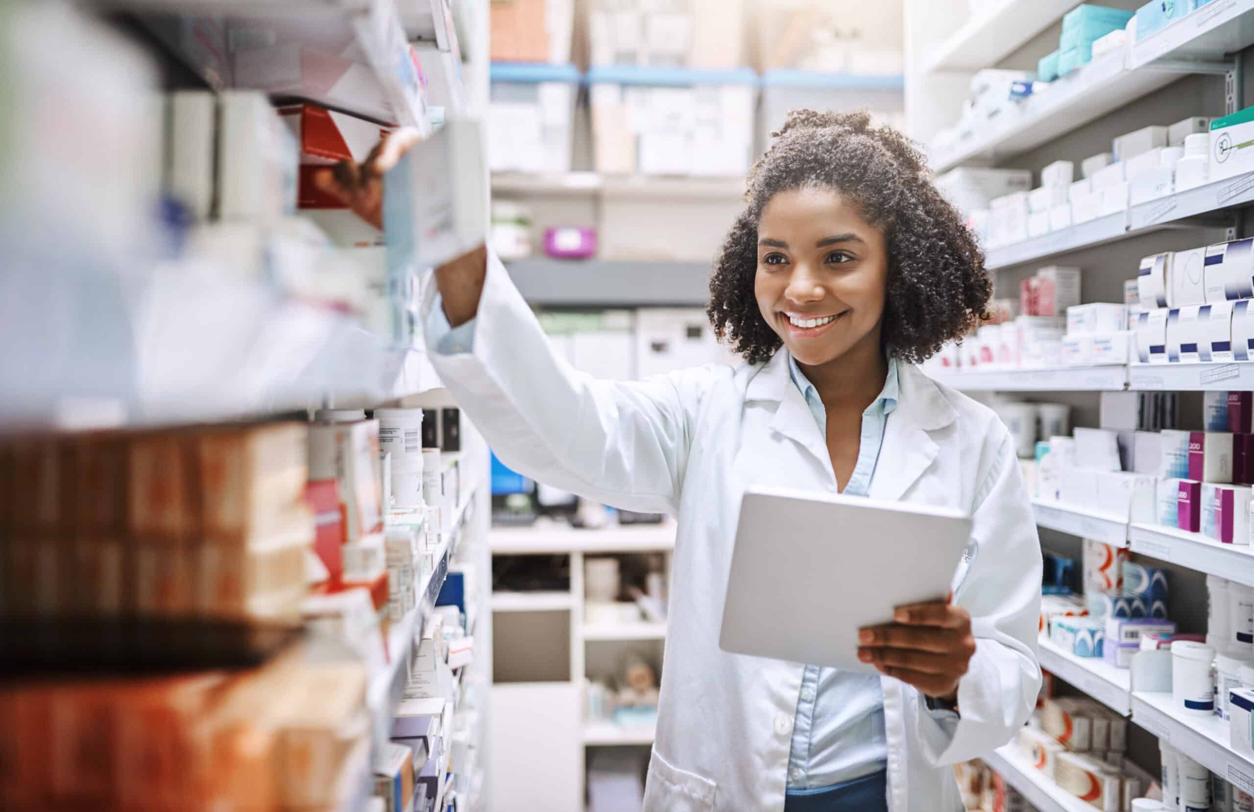 Pharmacy, healthcare and black woman with medicine, tablet and inventory with checklist in store for pills. Shop, person and smile for process of prescription, online and working of employee in job.